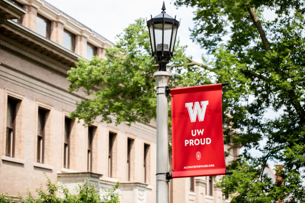 A banner on a lamp post that reads 'UW Proud'