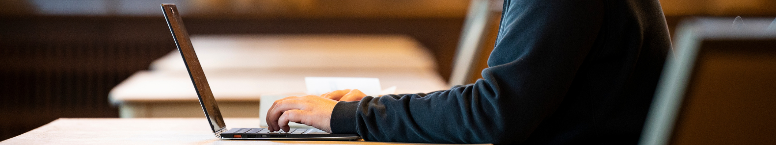 Hands typing on a computer